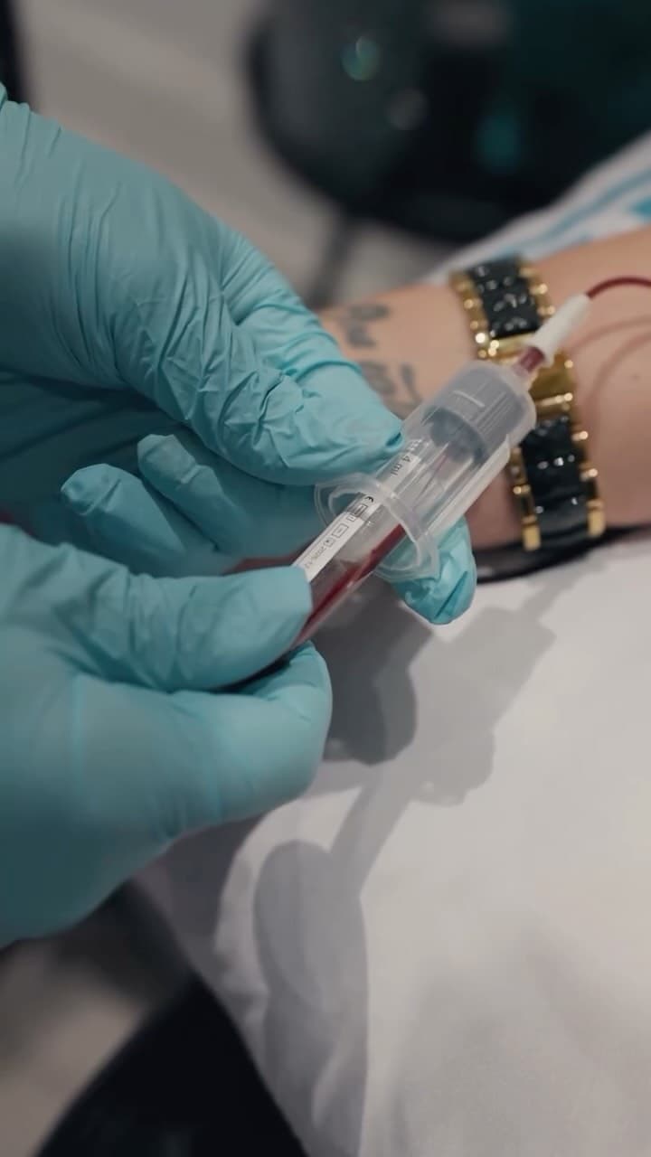 Clinician holding a blood sample tube during a consultation at Drip IV